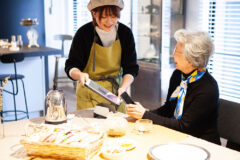 飲食店でタッチパネルの操作方法を聞く女性